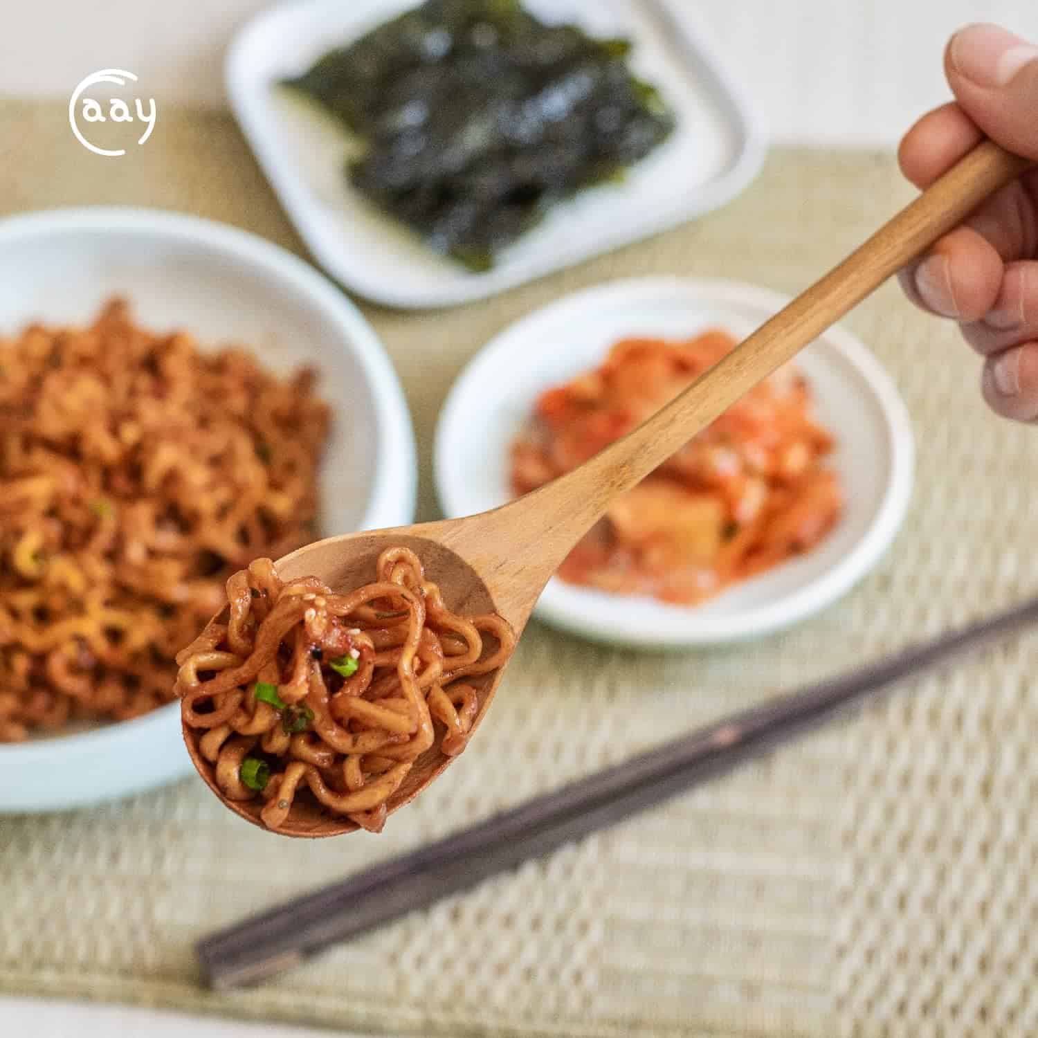 Delicious Korean ramen noodles with side dishes like seaweed, kimchi, and pickled vegetables in traditional presentation.